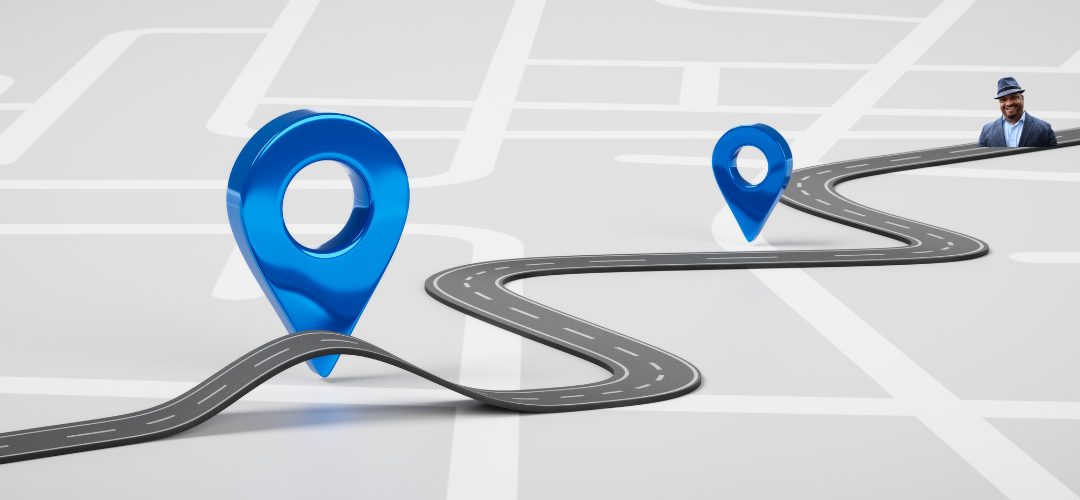 A stylized image of a winding road on a map, with two large blue map pin icons marking points along the route. A man in a suit and hat is positioned at the end of the road, conveying a sense of journey or destination.