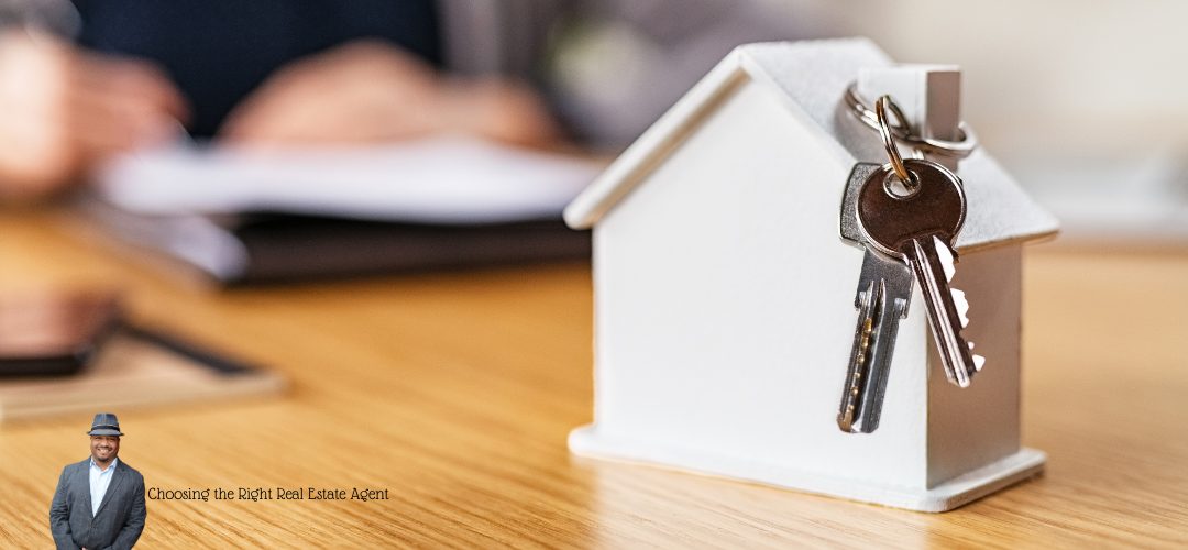 Miniature house model on a table with keys hanging from the roof. In the foreground, there's an image of a person in a suit and hat, with overlaid text reading "Choosing the Right Real Estate Agent." The blurred background suggests a professional setting.