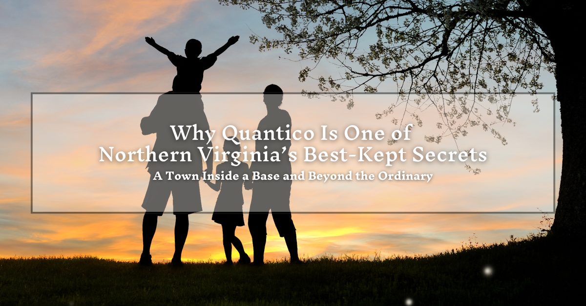 A silhouette of a family of four, consisting of two adults and two children, one on the shoulders of the adult, standing together under a tree against a sunset sky. The text overlay reads, "Why Quantico Is One of Northern Virginia’s Best-Kept Secrets - A Town Inside a Base and Beyond the Ordinary."