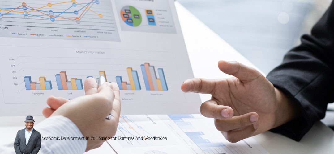 Hands of two people pointing at a printed sheet displaying various colorful graphs and charts, indicative of market analysis. A person in a suit is overlaid in the bottom left corner. Text on the image reads, "Economic Development In Full Swing for Dumfries And Woodbridge."